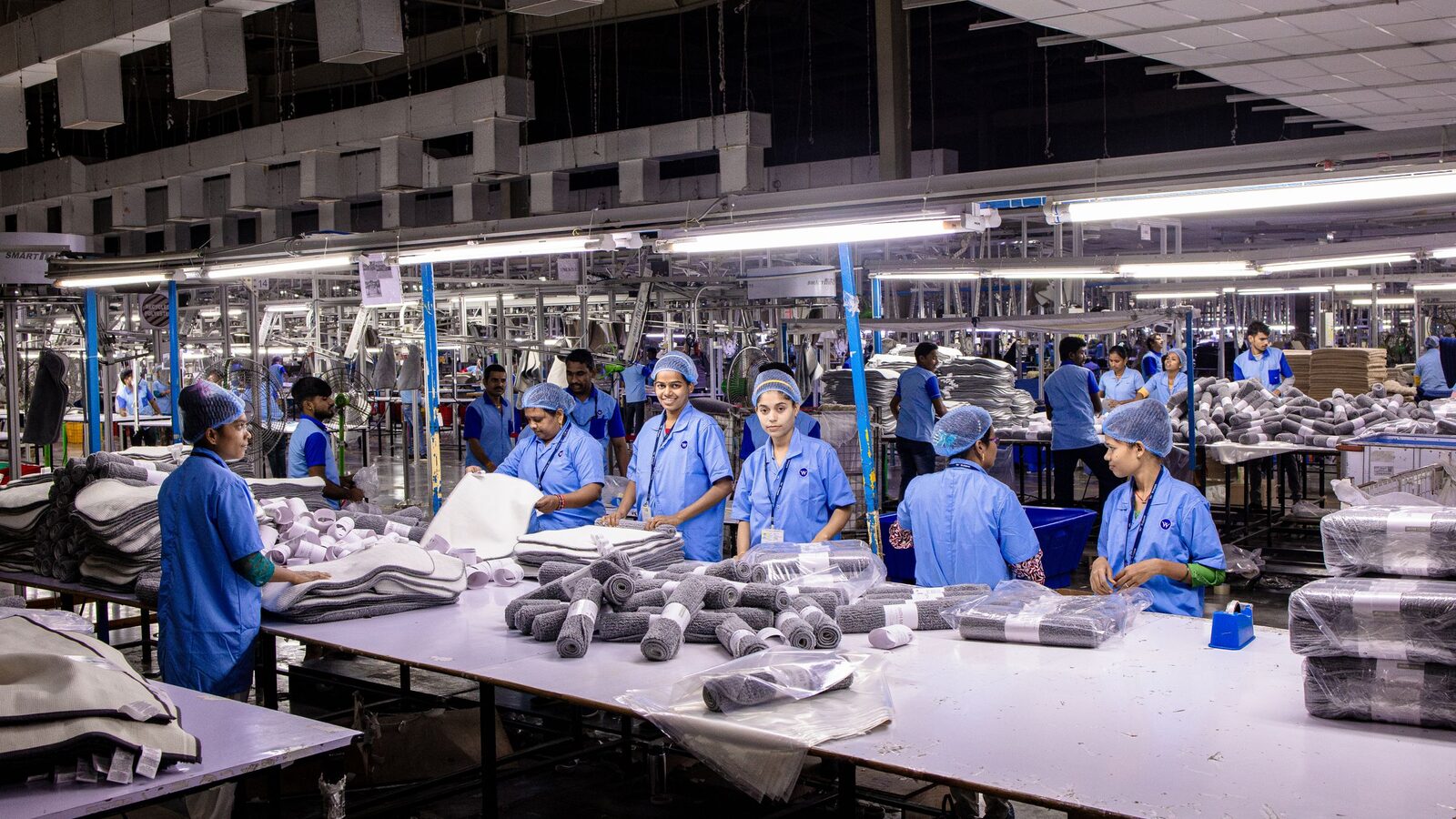 Workers packing finished goods on an assembly line in a textile factory