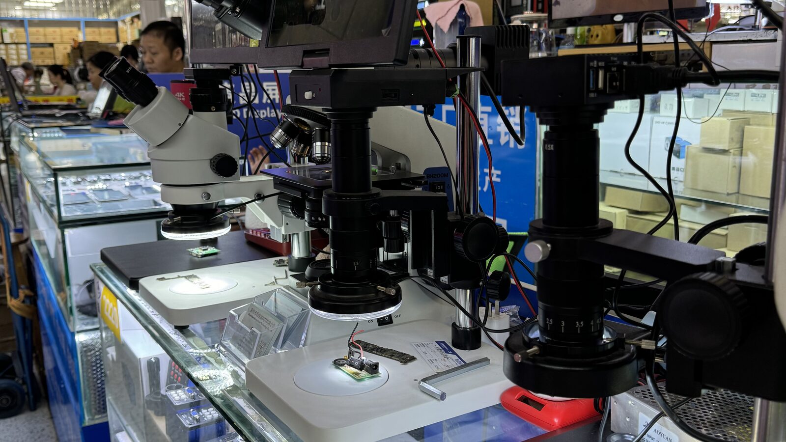 Inspection microscopes over circuit boards on a supplier's bench in Shenzhen